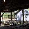 Screened-in Jack Pine Pavilion interior, featuring several picnic benches and lights.
