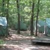 Six large green tents arranged in a circle on platforms at the Jack Pine tent site.
