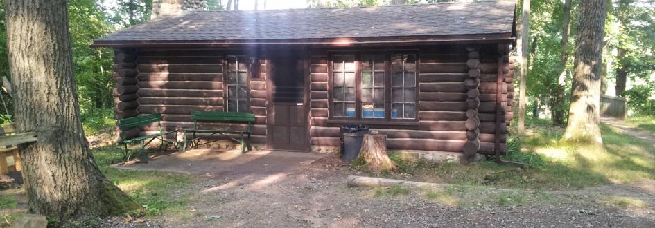 Roth Cabin with two green benches out front.